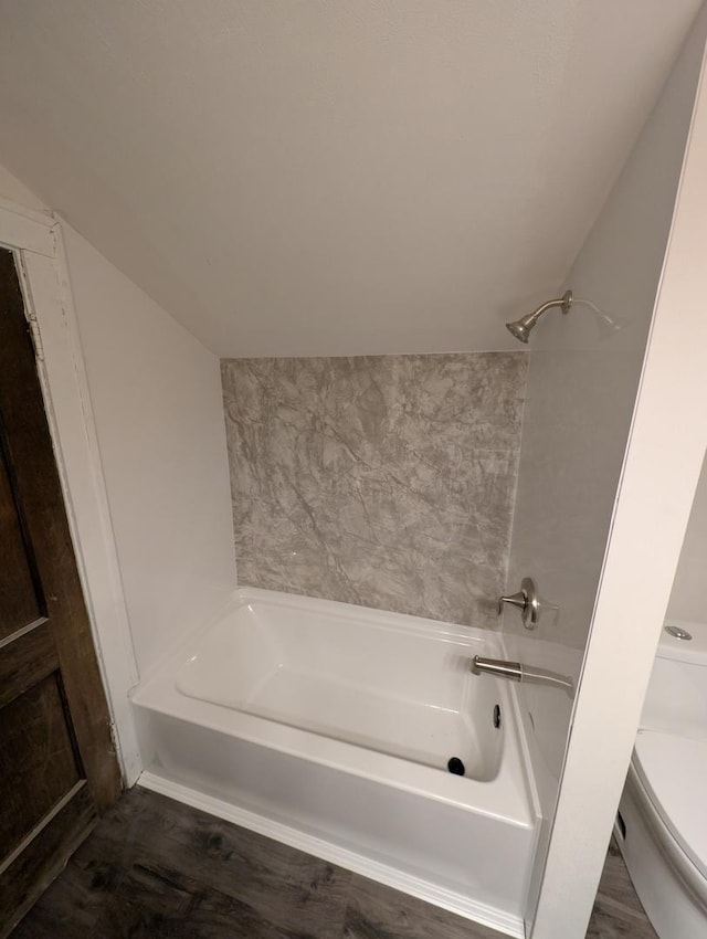 bathroom with shower / bathtub combination, lofted ceiling, and toilet