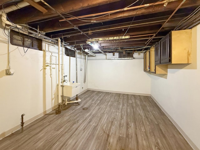 basement featuring sink and hardwood / wood-style floors