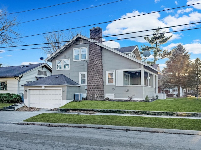 view of front of house featuring cooling unit, a garage, and a front yard