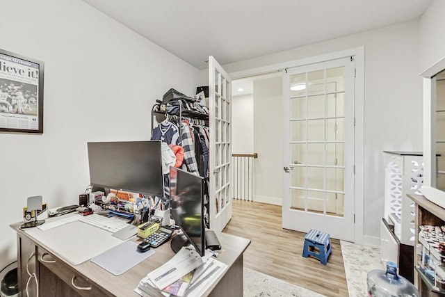 office with light wood finished floors, baseboards, and french doors