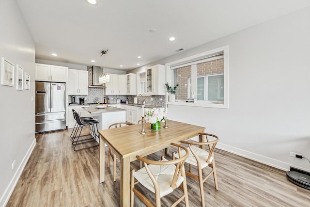 dining room with light wood-type flooring, baseboards, and recessed lighting