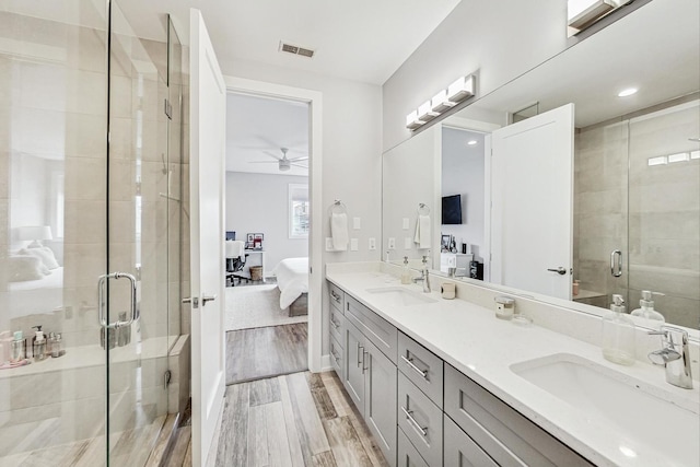 full bathroom featuring a shower stall, wood finished floors, a sink, and ensuite bathroom