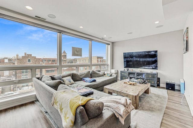 living room featuring a view of city, baseboards, light wood finished floors, and recessed lighting