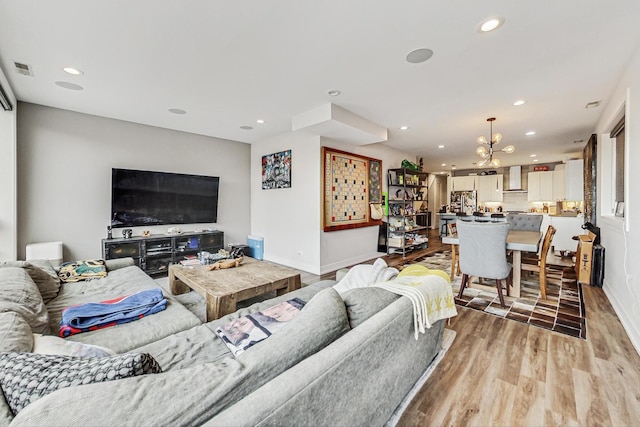 living room with light wood-style flooring, visible vents, baseboards, and recessed lighting