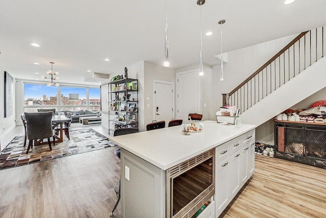 kitchen with a kitchen island, open floor plan, decorative light fixtures, a view of city, and light countertops