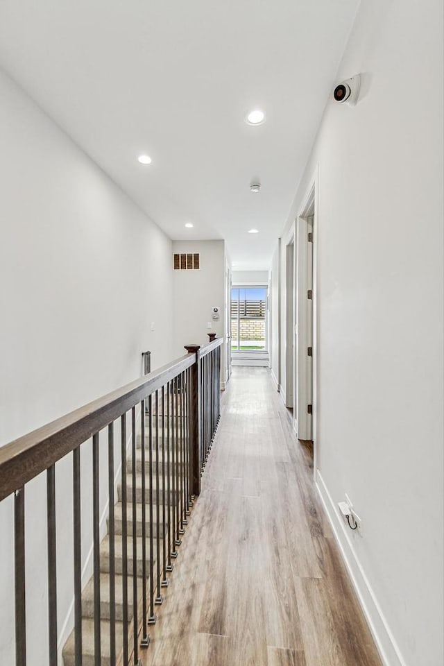 hallway featuring recessed lighting, visible vents, light wood-style flooring, and baseboards