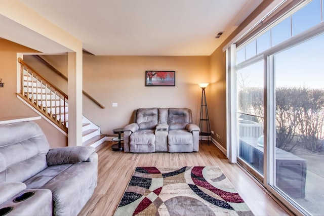 living room with stairs, baseboards, and wood finished floors