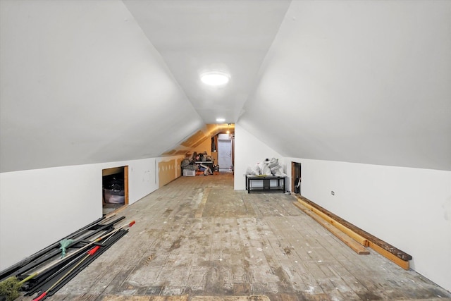 additional living space featuring vaulted ceiling and hardwood / wood-style floors