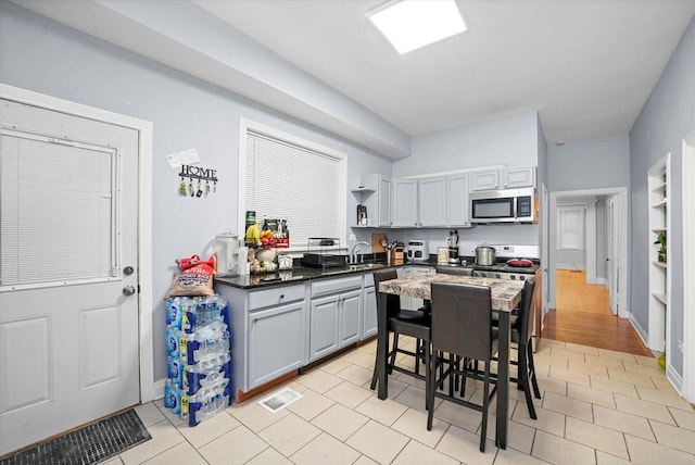 kitchen with stainless steel appliances, light tile patterned flooring, and sink