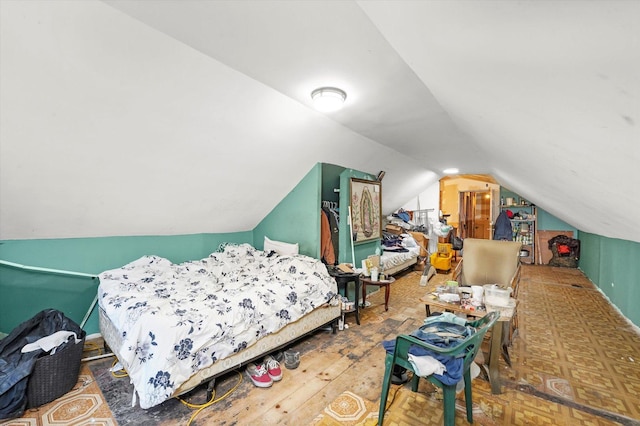 bedroom with wood-type flooring and vaulted ceiling