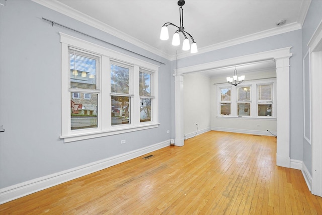 unfurnished dining area with crown molding, light hardwood / wood-style floors, and a notable chandelier