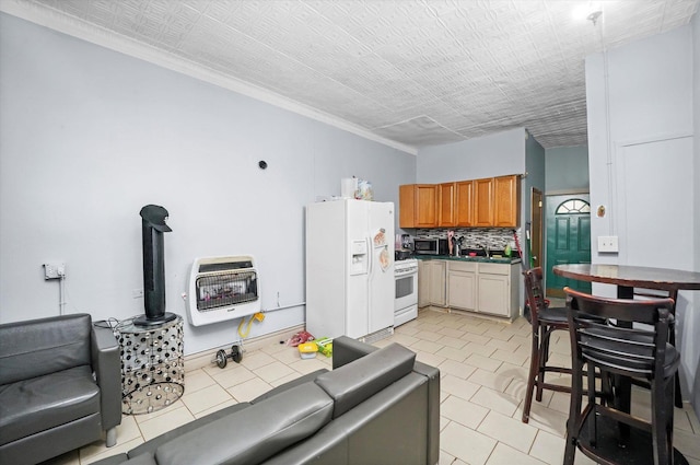 kitchen with tasteful backsplash, white appliances, ornamental molding, and heating unit