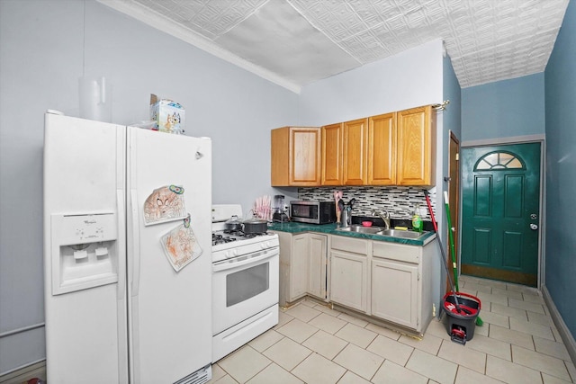 kitchen with tasteful backsplash, white appliances, and sink