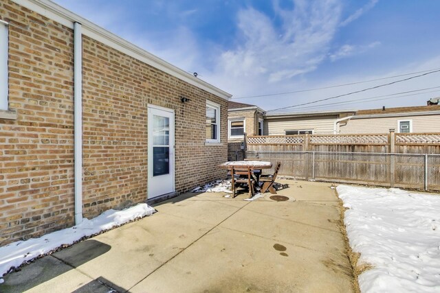 snow covered patio featuring fence