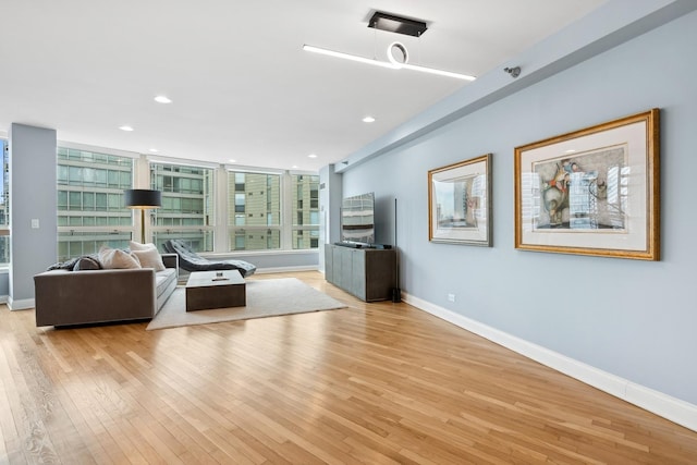 living area with recessed lighting, baseboards, and light wood finished floors