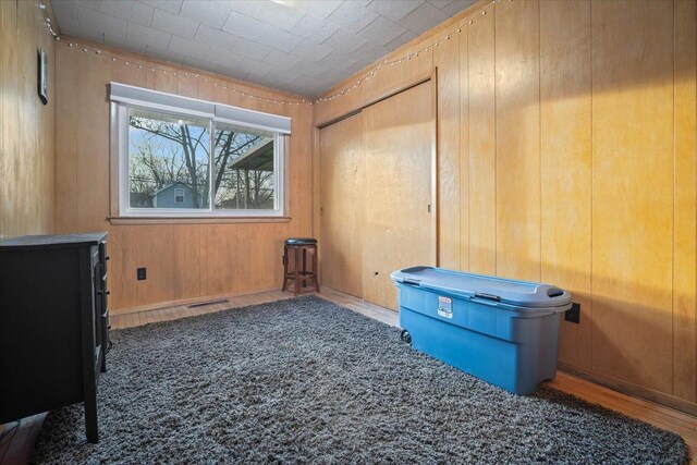 miscellaneous room featuring hardwood / wood-style flooring and wooden walls