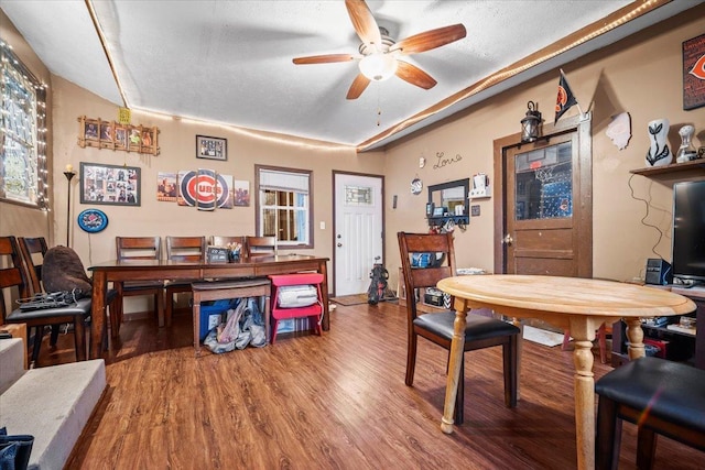 dining room featuring ceiling fan, hardwood / wood-style floors, and a textured ceiling