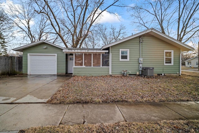 single story home with a garage, central AC, and a sunroom