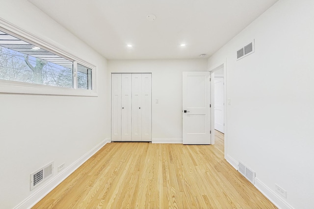 unfurnished bedroom with light hardwood / wood-style floors and a closet