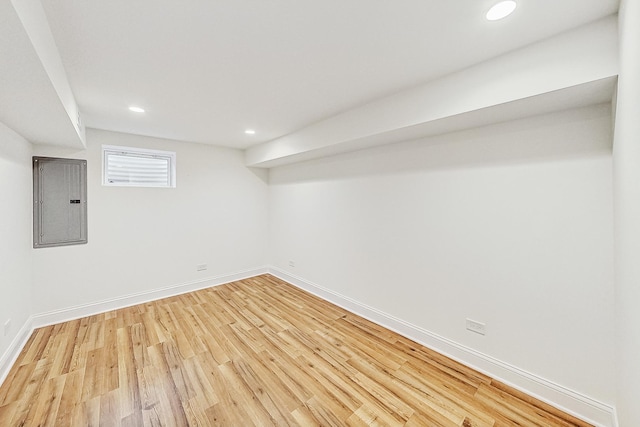 basement featuring hardwood / wood-style flooring and electric panel