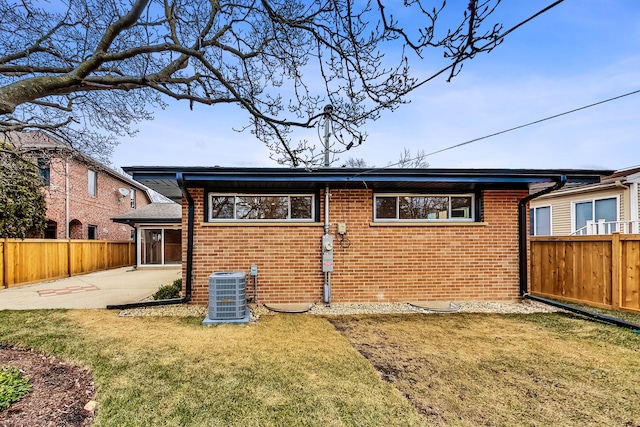 back of property with cooling unit, a yard, and a patio