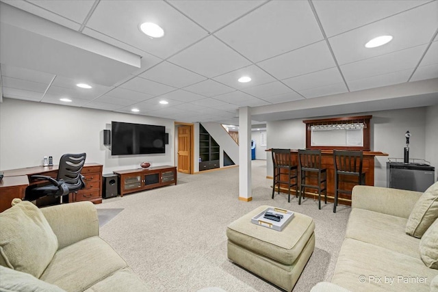 carpeted living area featuring recessed lighting, a paneled ceiling, a dry bar, and stairs