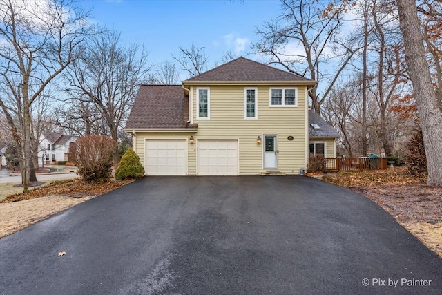 view of front of house with a shingled roof, driveway, and a deck