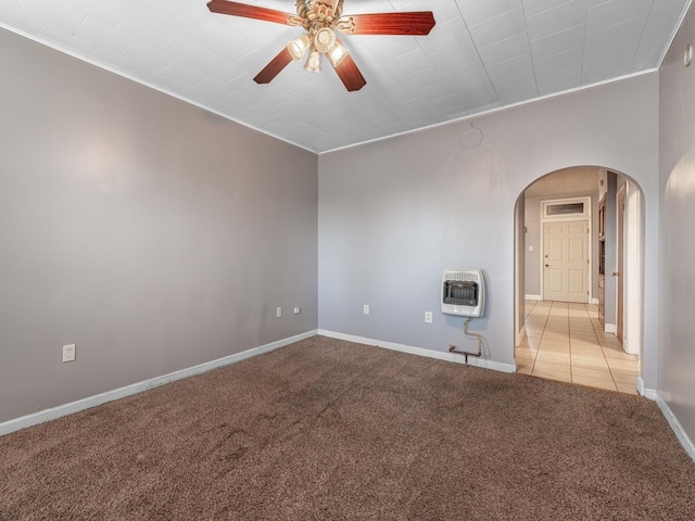 empty room with crown molding, heating unit, light colored carpet, and ceiling fan