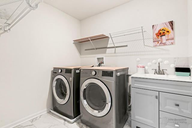 laundry room featuring cabinets, washing machine and dryer, and sink