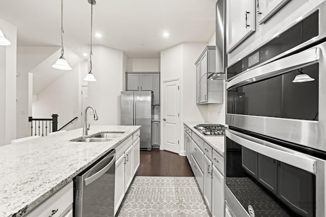 kitchen featuring sink, gray cabinetry, hanging light fixtures, stainless steel appliances, and light stone counters