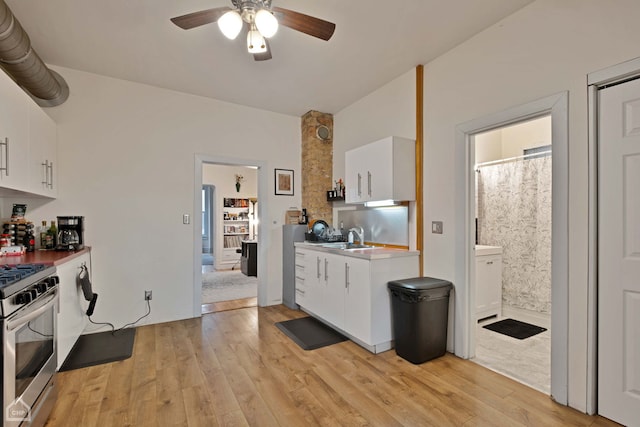 kitchen featuring white cabinetry, stainless steel range, sink, and light hardwood / wood-style floors