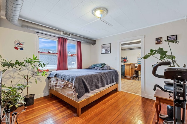 bedroom with wood-type flooring and ornamental molding