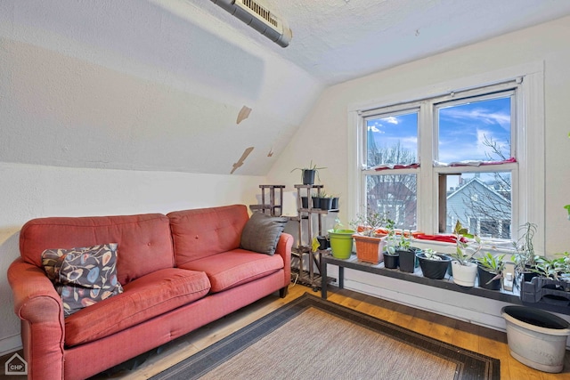 living room with lofted ceiling, hardwood / wood-style floors, and a textured ceiling