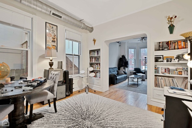 home office with light hardwood / wood-style flooring and ceiling fan