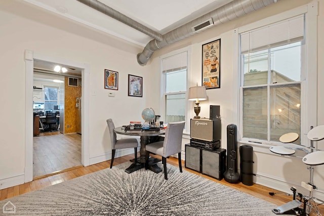 home office featuring hardwood / wood-style flooring, a healthy amount of sunlight, and beamed ceiling