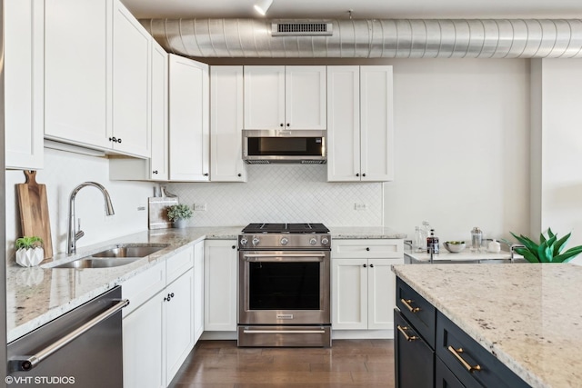 kitchen featuring sink, light stone countertops, white cabinets, and appliances with stainless steel finishes