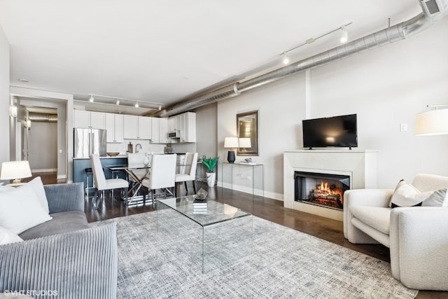 living room with track lighting and dark hardwood / wood-style floors