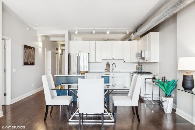 dining space featuring sink and dark wood-type flooring