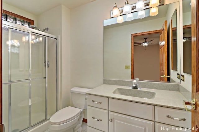 bathroom featuring vanity, toilet, and a shower with shower door