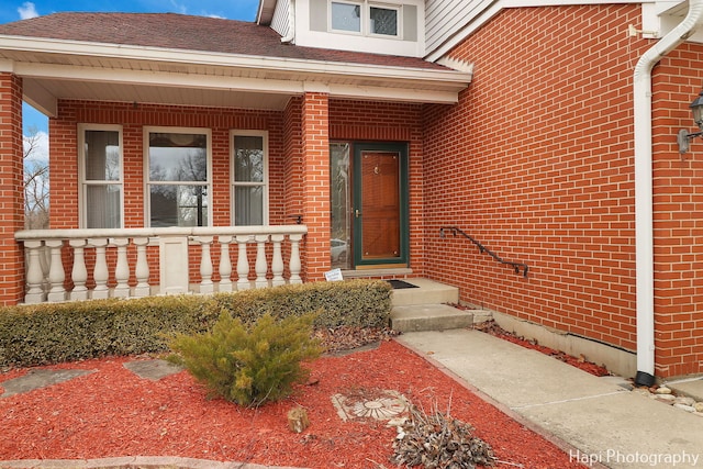 view of exterior entry featuring covered porch