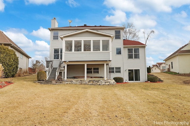 rear view of property with a sunroom and a yard