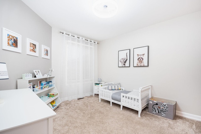 bedroom featuring light carpet and a nursery area