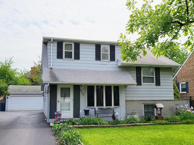 view of front of property featuring a garage, an outdoor structure, and a front lawn