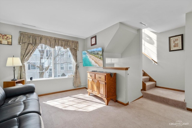 living area with visible vents, light colored carpet, stairs, and baseboards