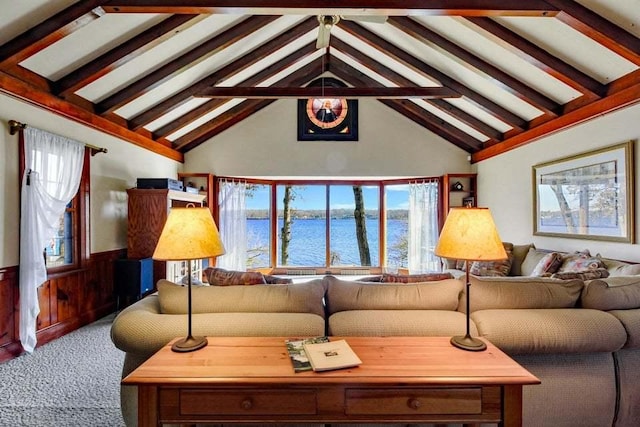 carpeted living room featuring a water view, wooden walls, beam ceiling, and high vaulted ceiling