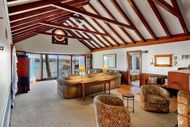 living room featuring beam ceiling and high vaulted ceiling