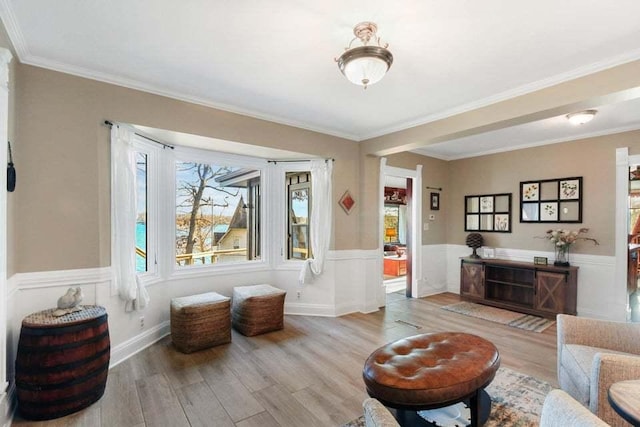 living room with crown molding and light hardwood / wood-style flooring