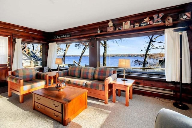 living room featuring a water view, a baseboard heating unit, and light carpet