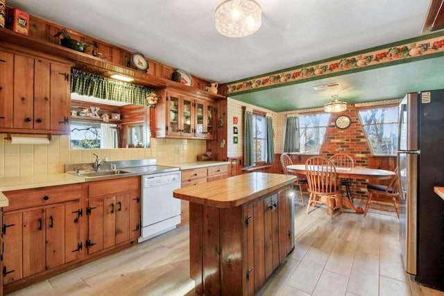 kitchen featuring sink, pendant lighting, stainless steel fridge, and white dishwasher