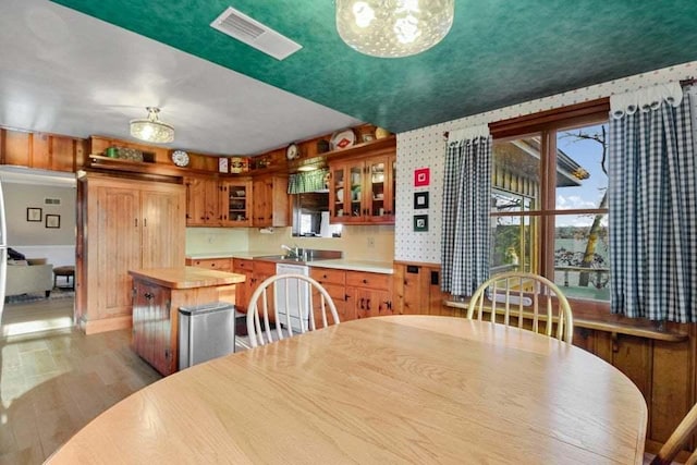 dining room with sink, a wealth of natural light, a chandelier, and light hardwood / wood-style flooring